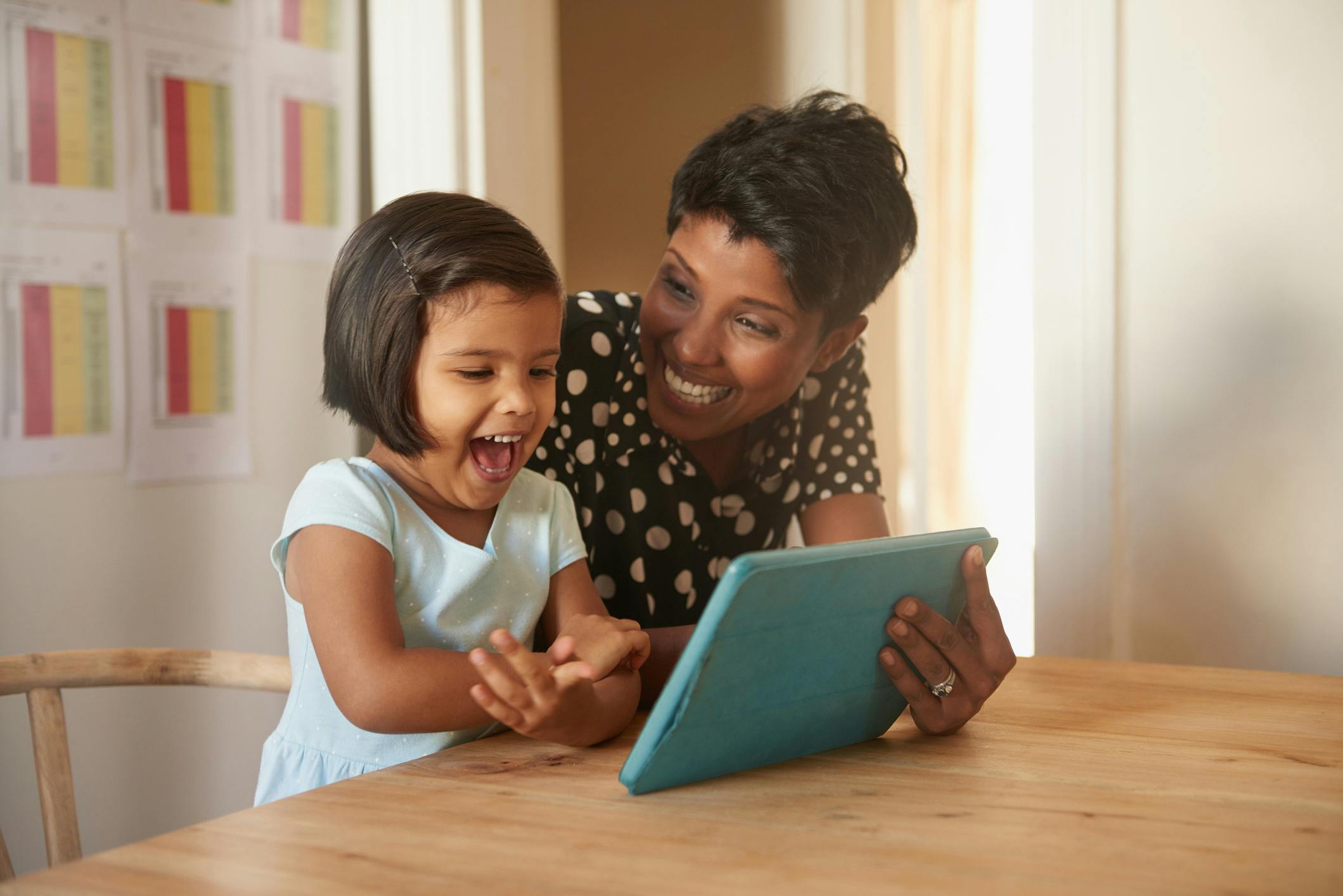 Mother and daughter smiling while exploring Prodigy Level Up features on their tablet.