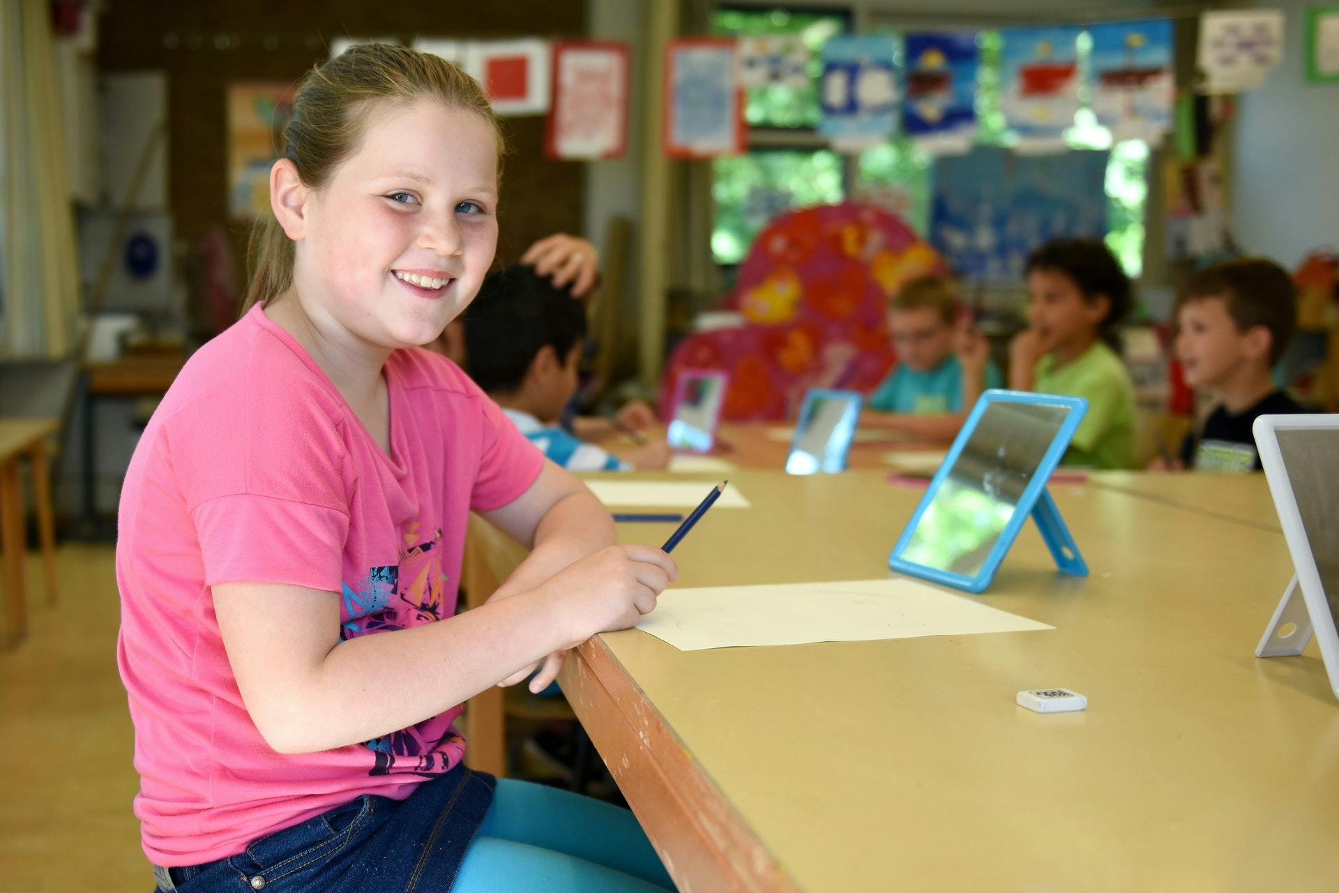 Young elementary student play on a tablet during math class