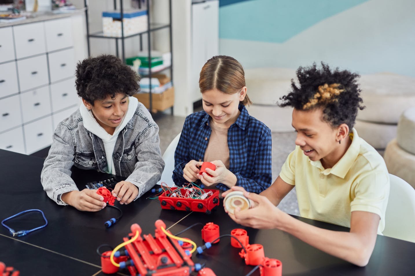 Three students doing a robotics project together in their after-school STEM program.