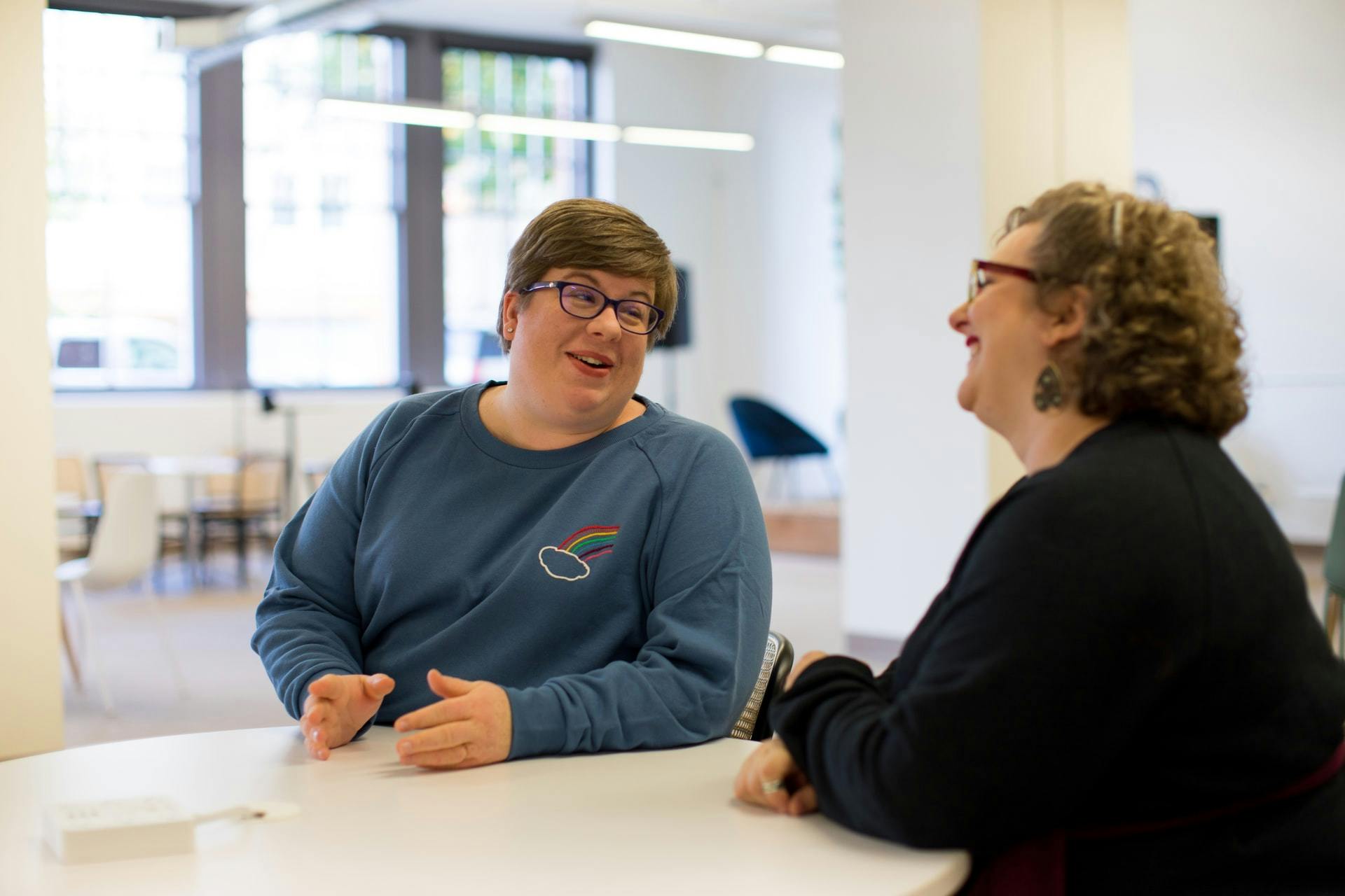 A teacher and a parent having a conversation at school.