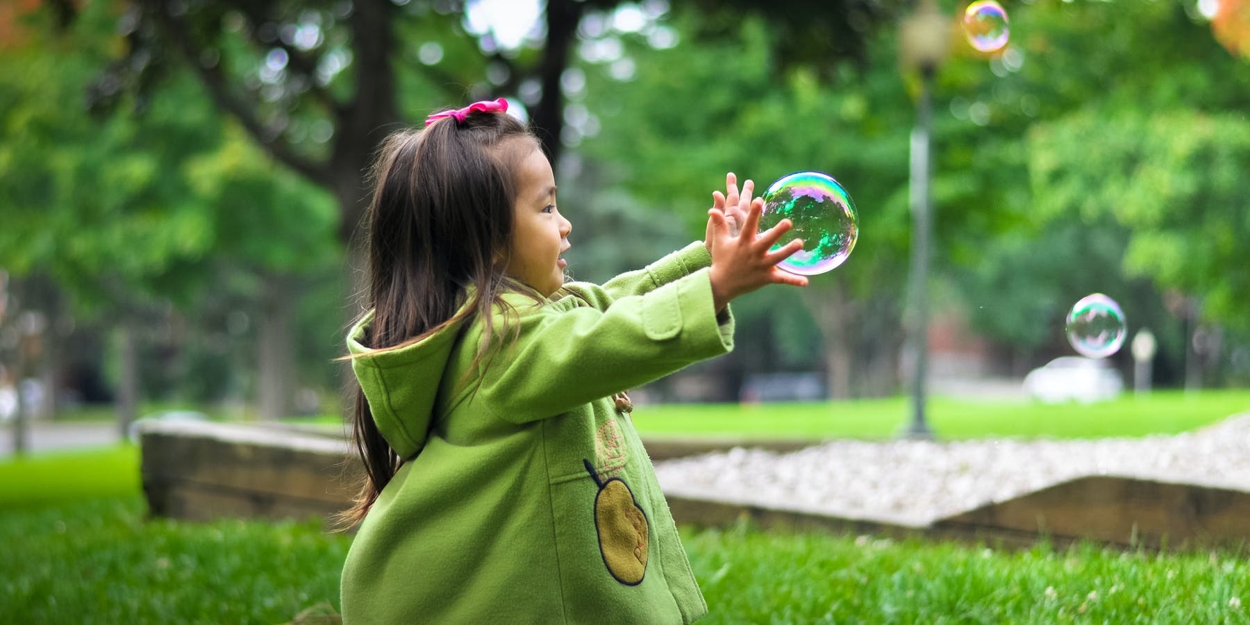 Girl playing with bubble outdoors.