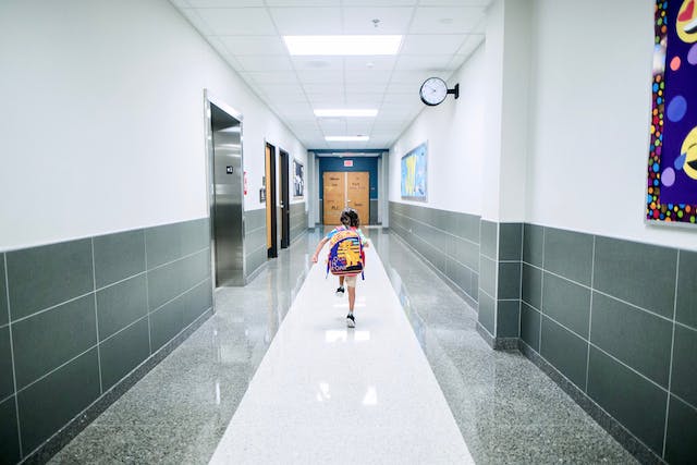 Student walking in empty school hallway
