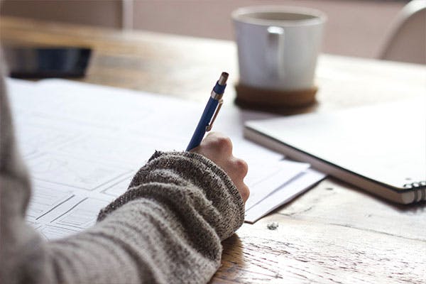 Teacher writing at desk.