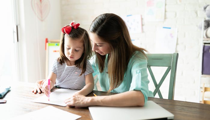 Mom homeschooling her child using math programs.