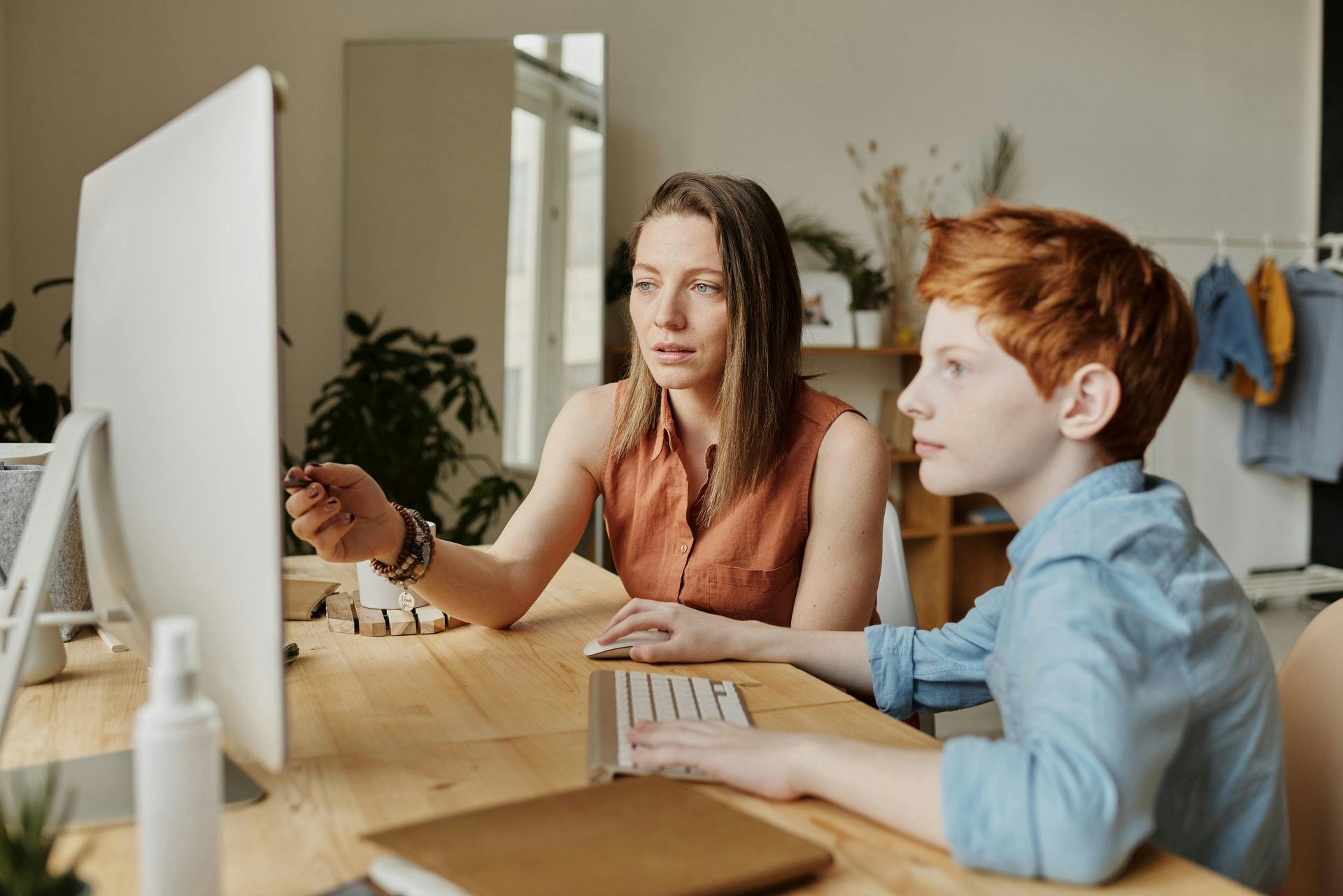 A parent and student sit on a computer during test prep season. 