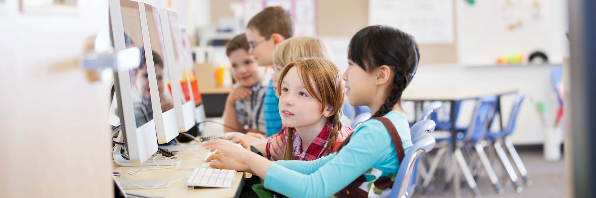 Elementary students playing subtraction games on computers.