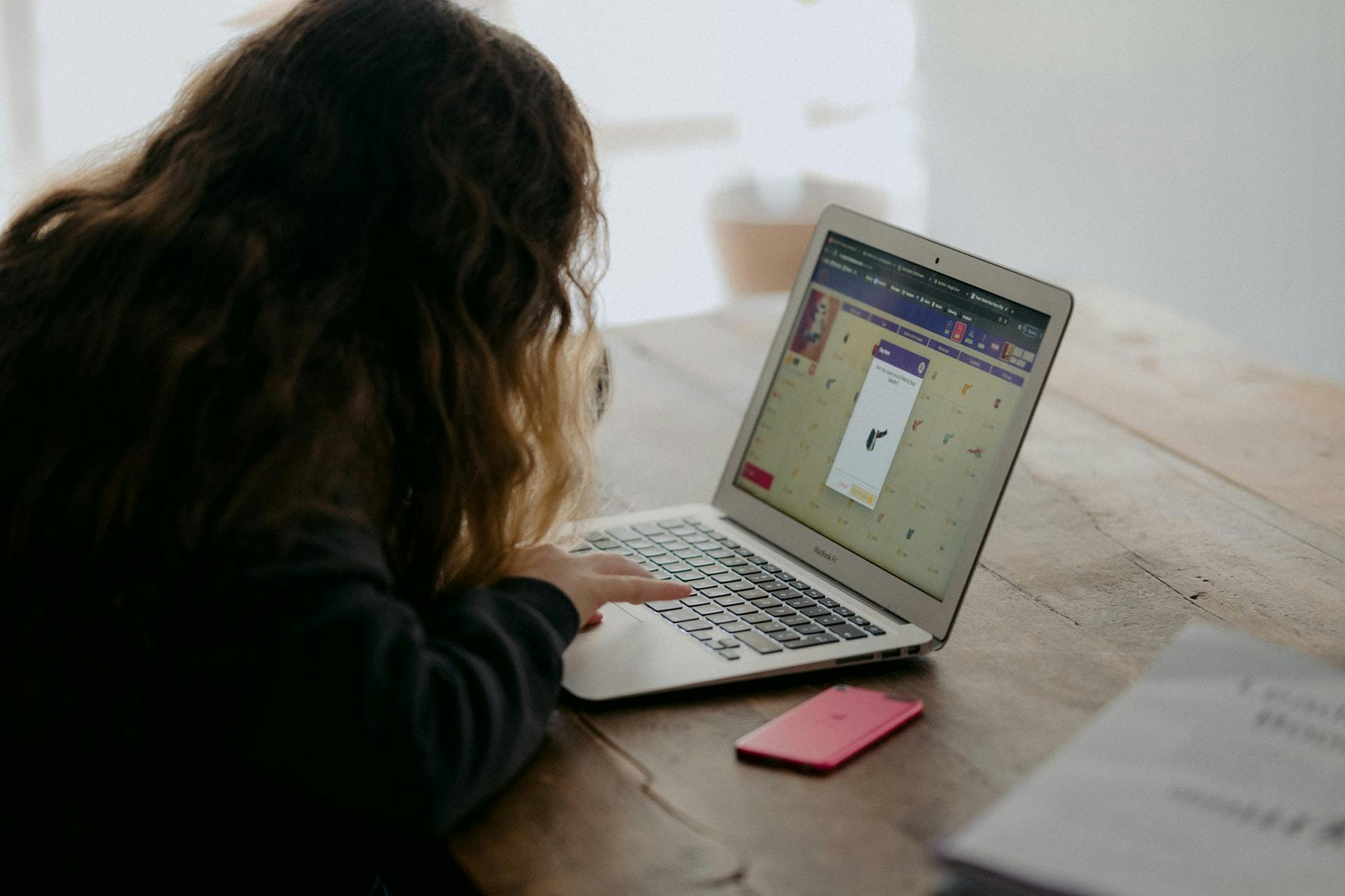 A student works on a computer using distance learning tools as she ...
