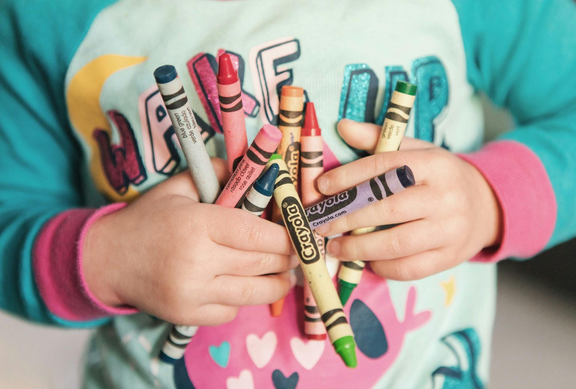 child holding crayons