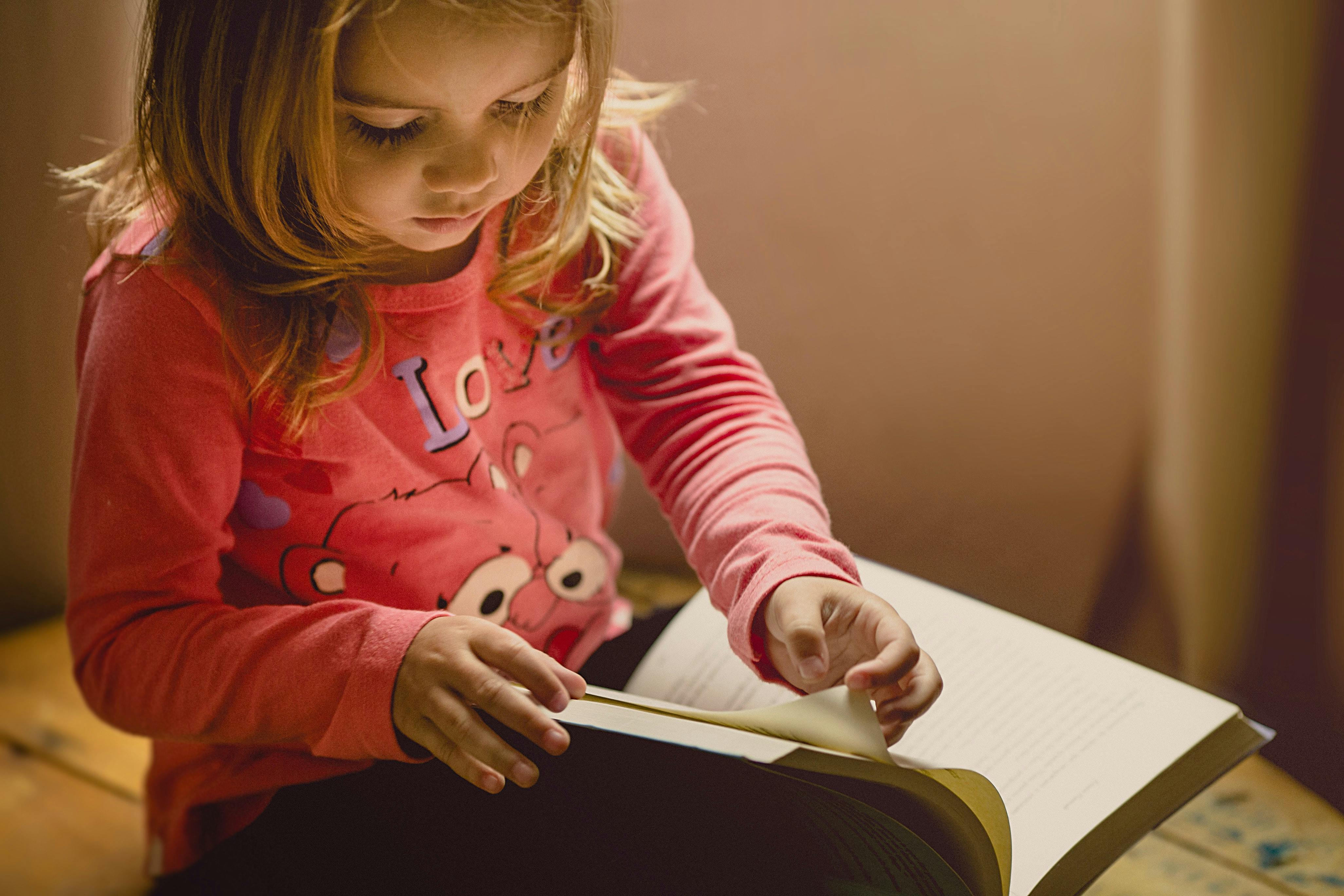 A young girl practicing first grade reading skills.