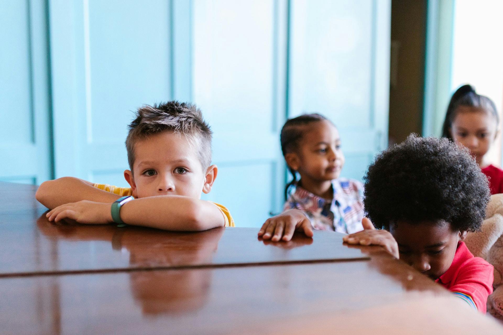 Children stand at a table during restorative practice activities.