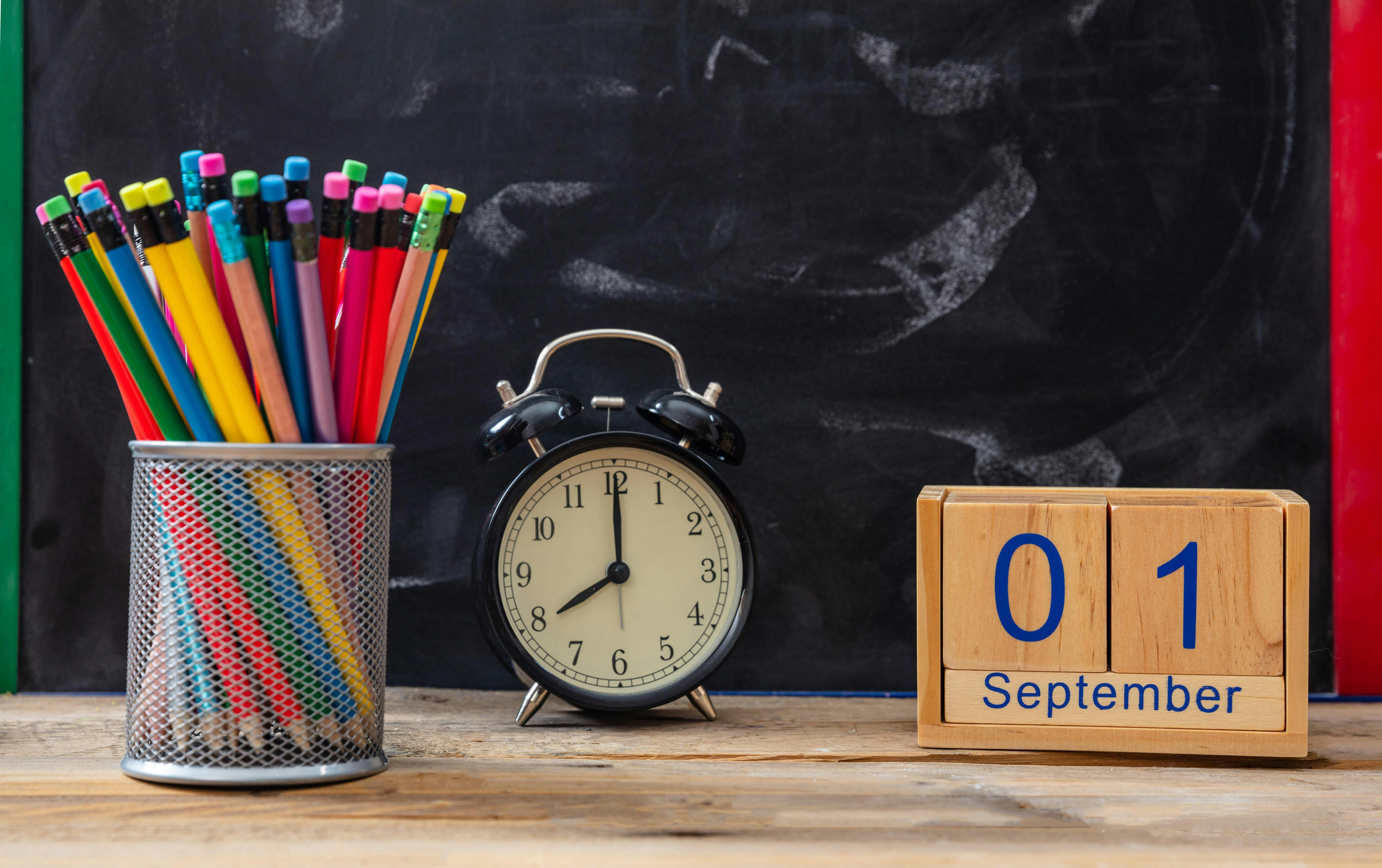 organized desk with pencils and clock