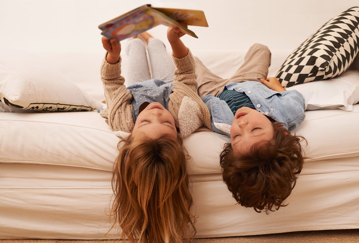 Child reading to her sibling to help them improve their reading comprehension.