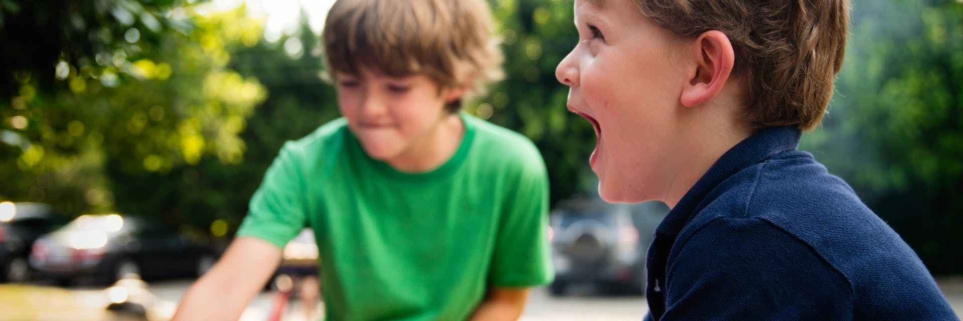 Two boys smile and play outside while doing fun earth day activities for kids. 