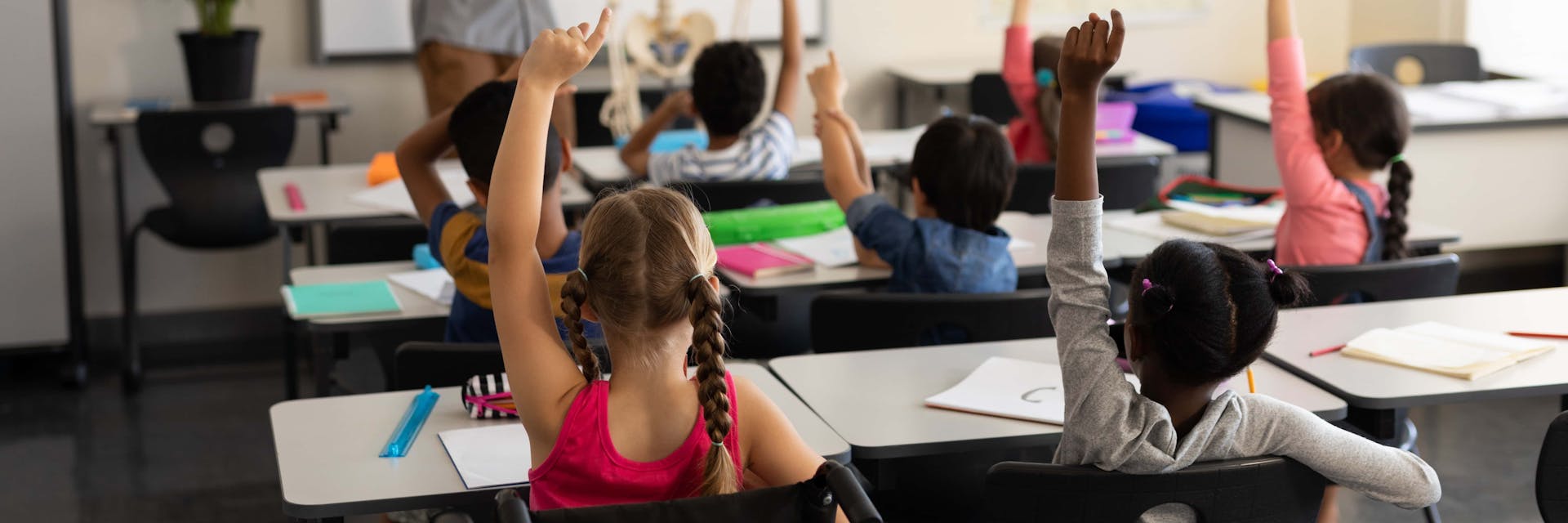 Students raising hands in a gifted classroom.