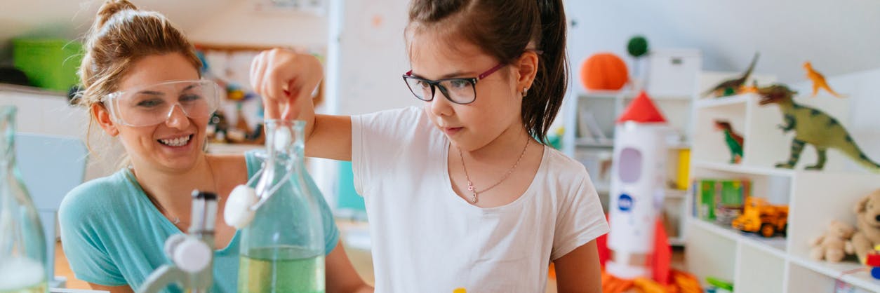 Child and her parent doing a science experiment at home together from their online STEM program.