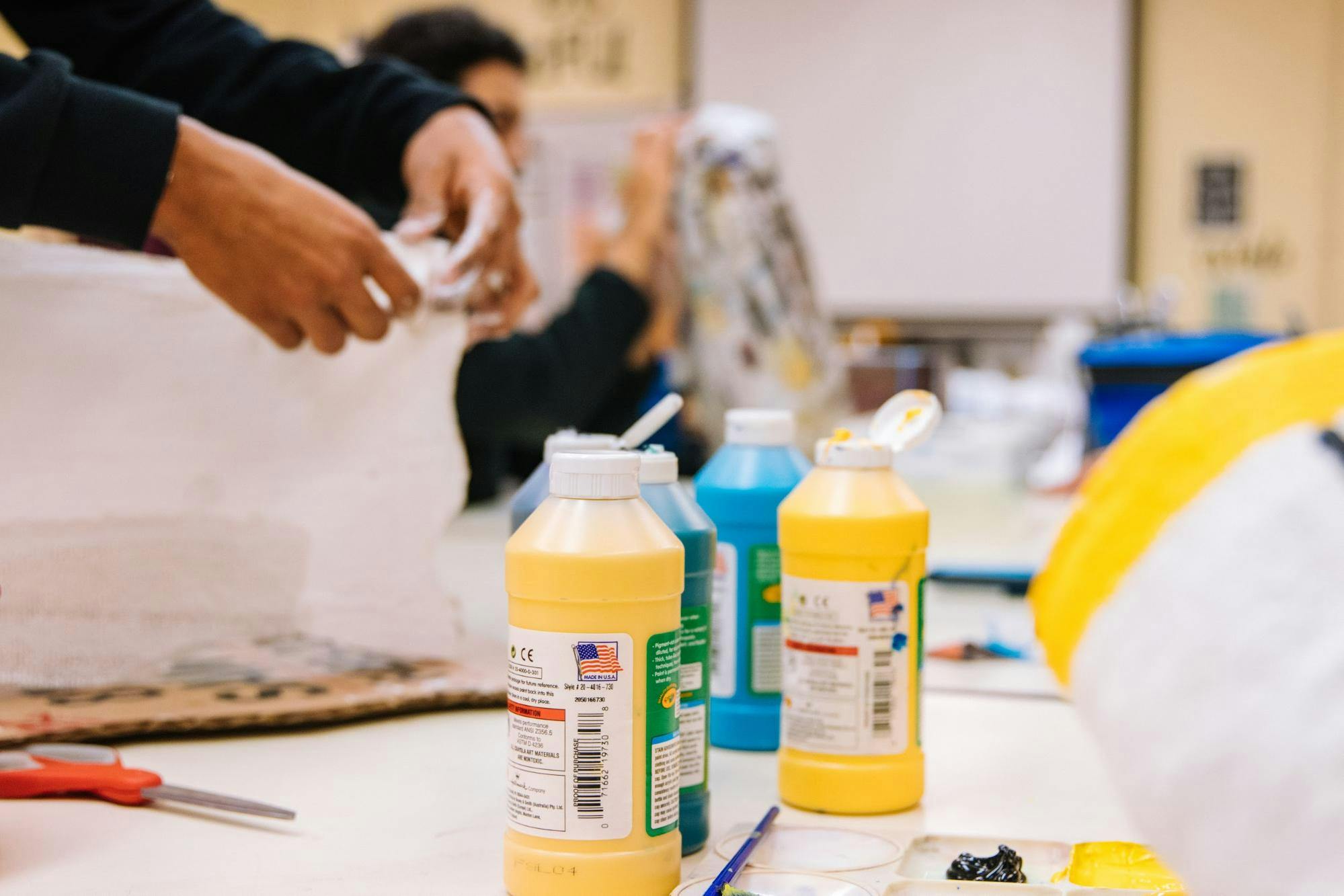 Children use paint, scissors and other craft supplies in the classroom.