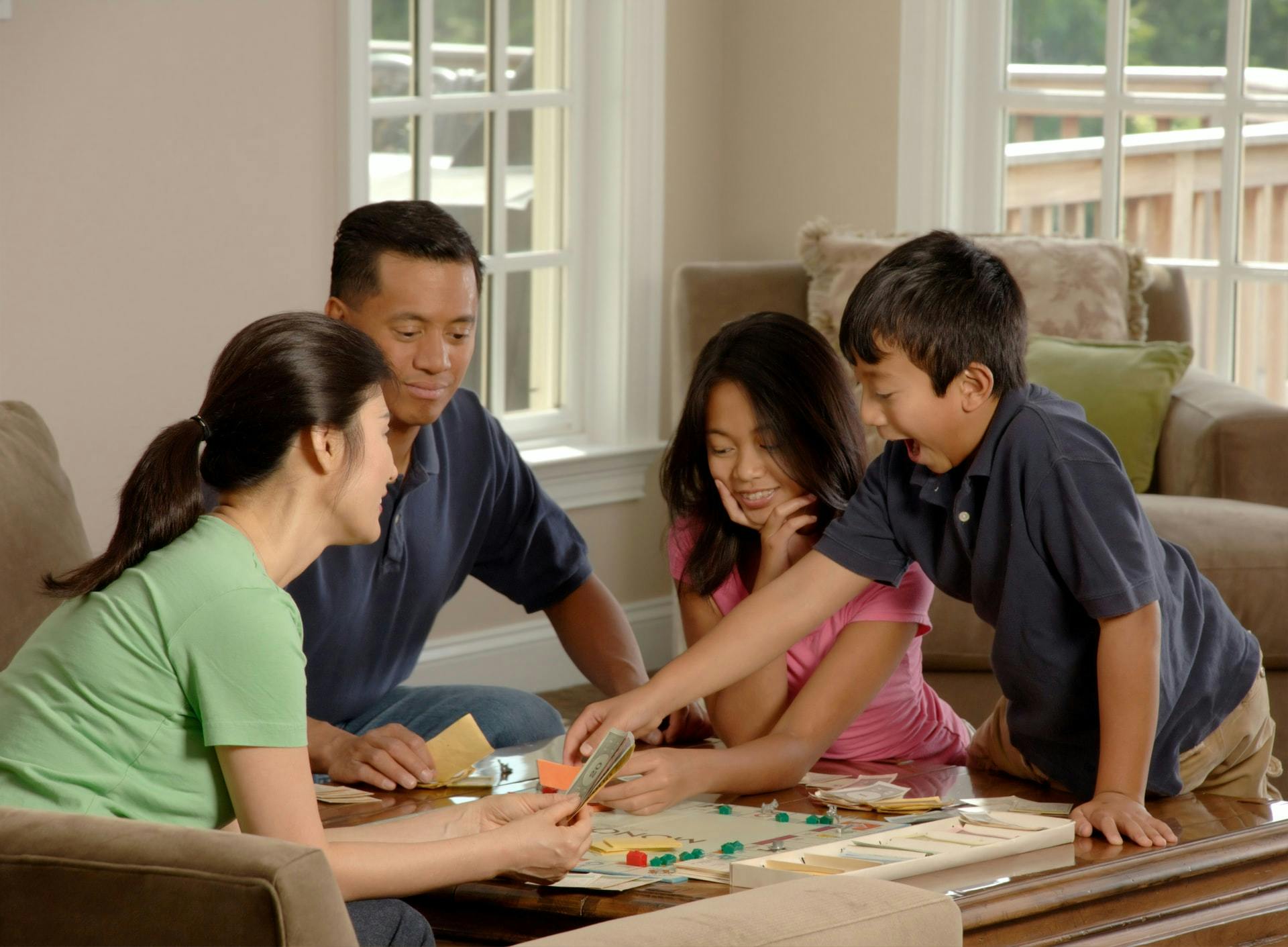 A family of four plays a word board game together.