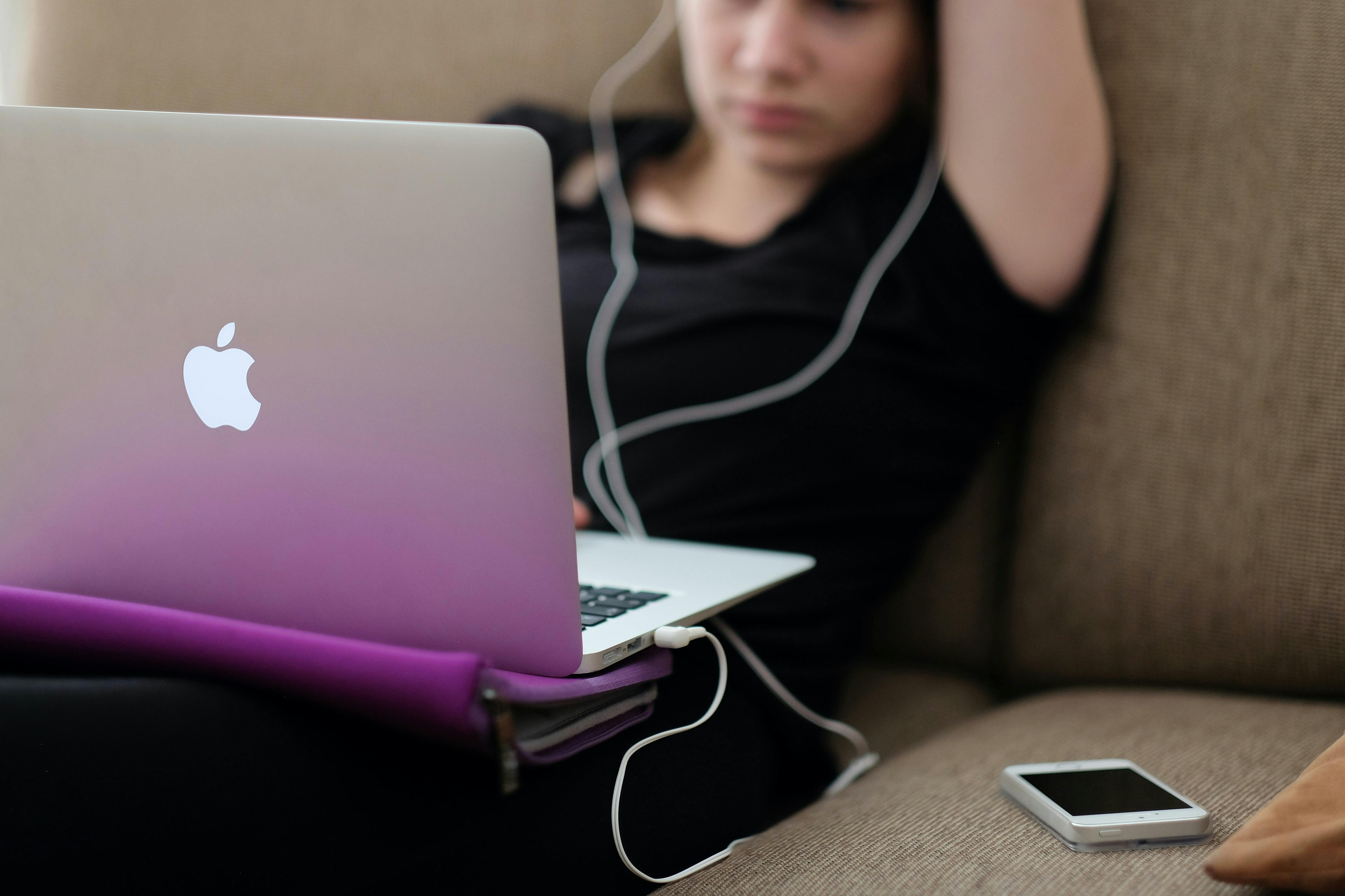 Girl laying on couch on her laptop.