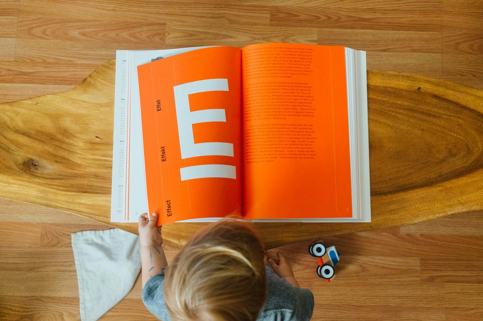 Overhead shot of child looking through letter book as they practice ell skills. 