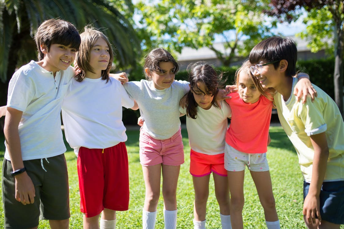 A group of students huddle outside and think of a strategy for team building activities.