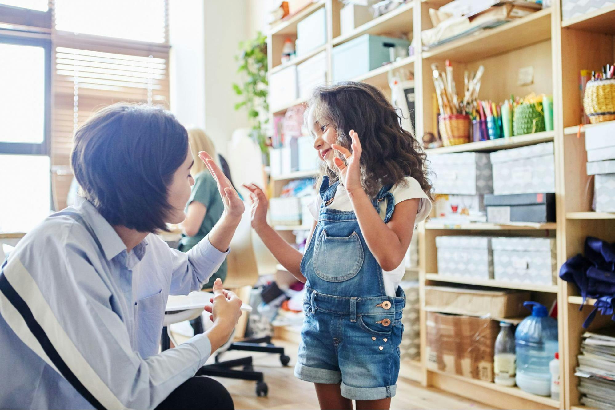 Teacher and student high five during a fun classroom activity.