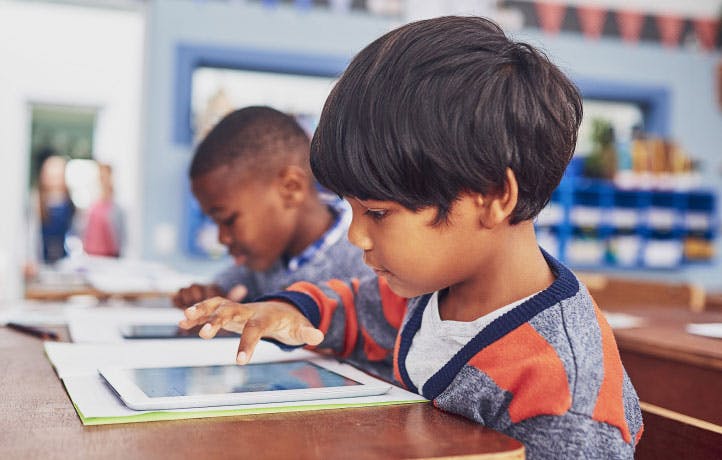 Two students play math and English games on tablet devices.