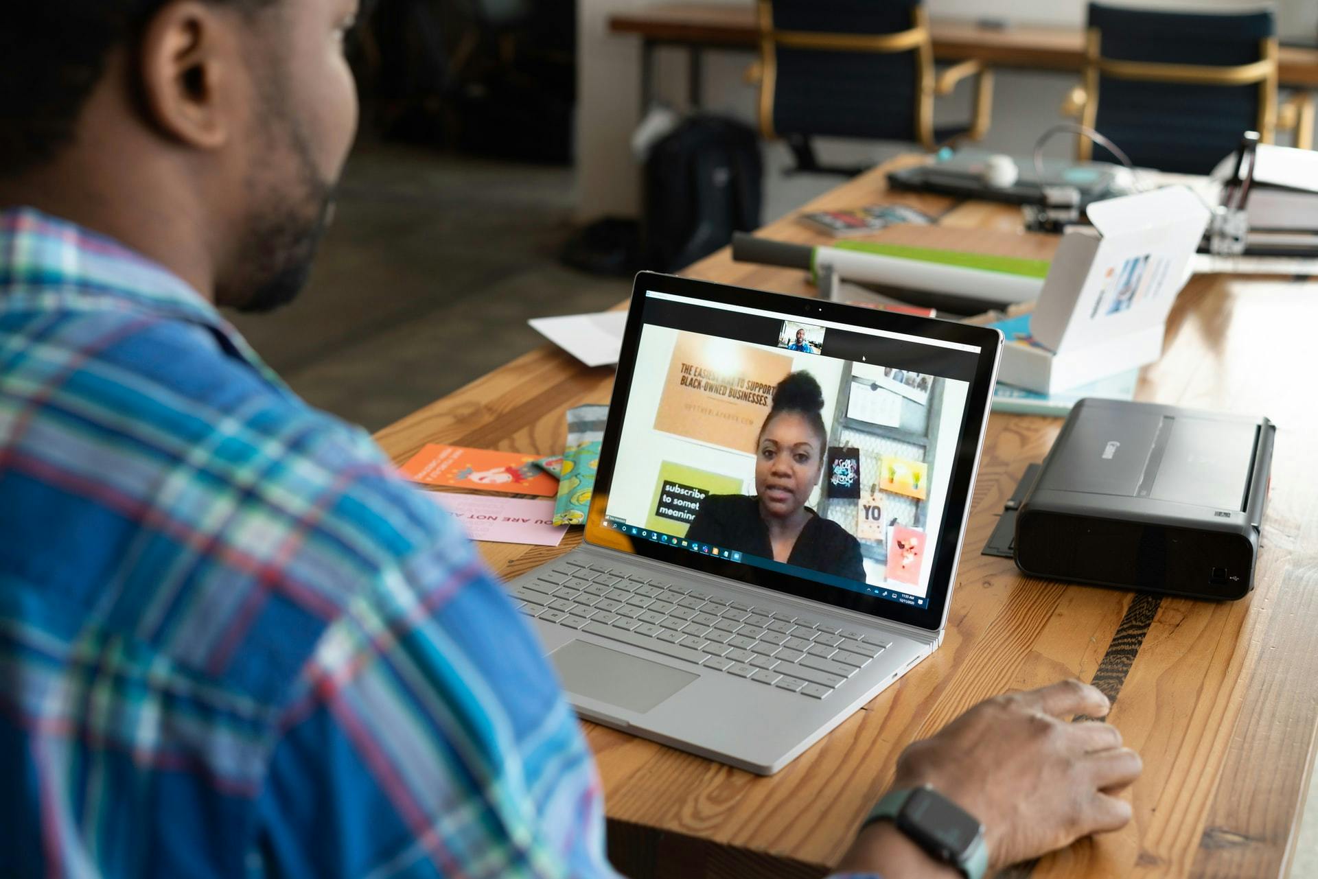 Two teachers chat online through a video conferencing program on a laptop.