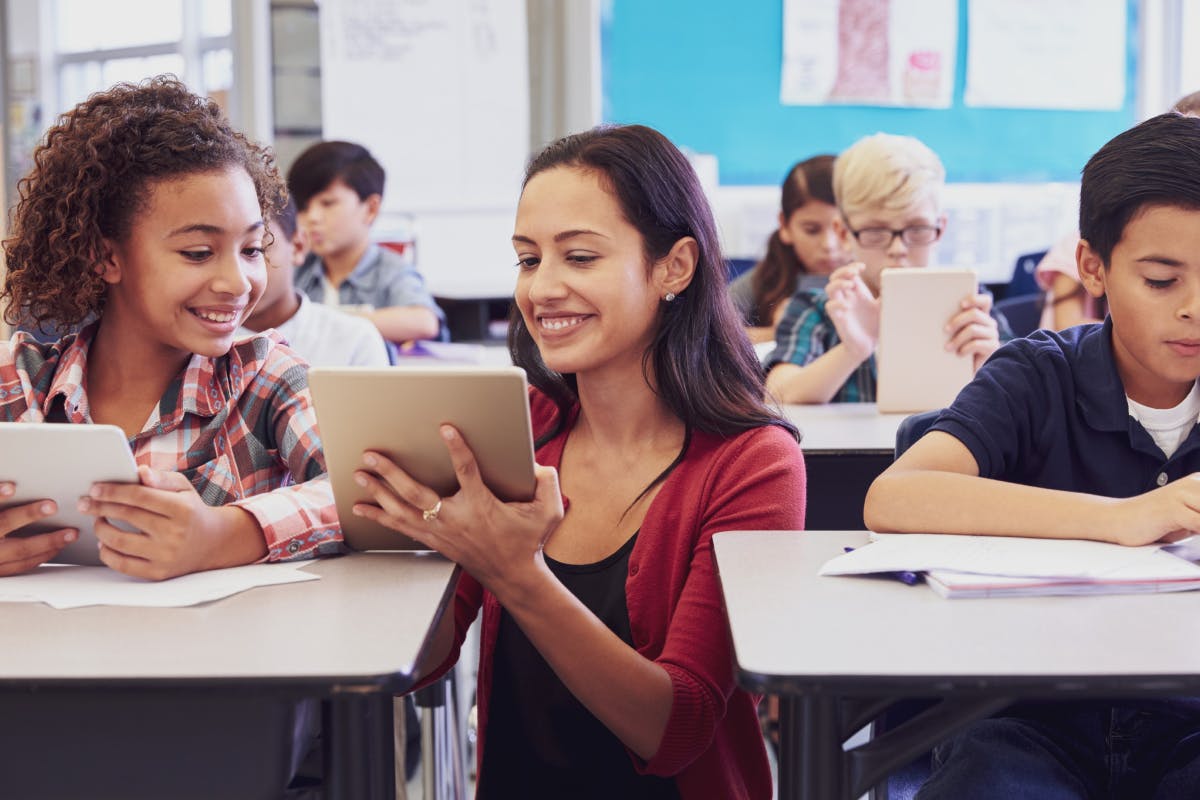 Teacher guiding student on tablet