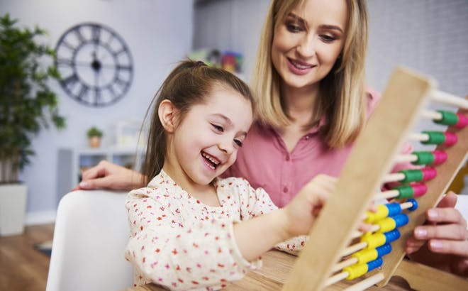 Mom using abacus to homeschool her child.