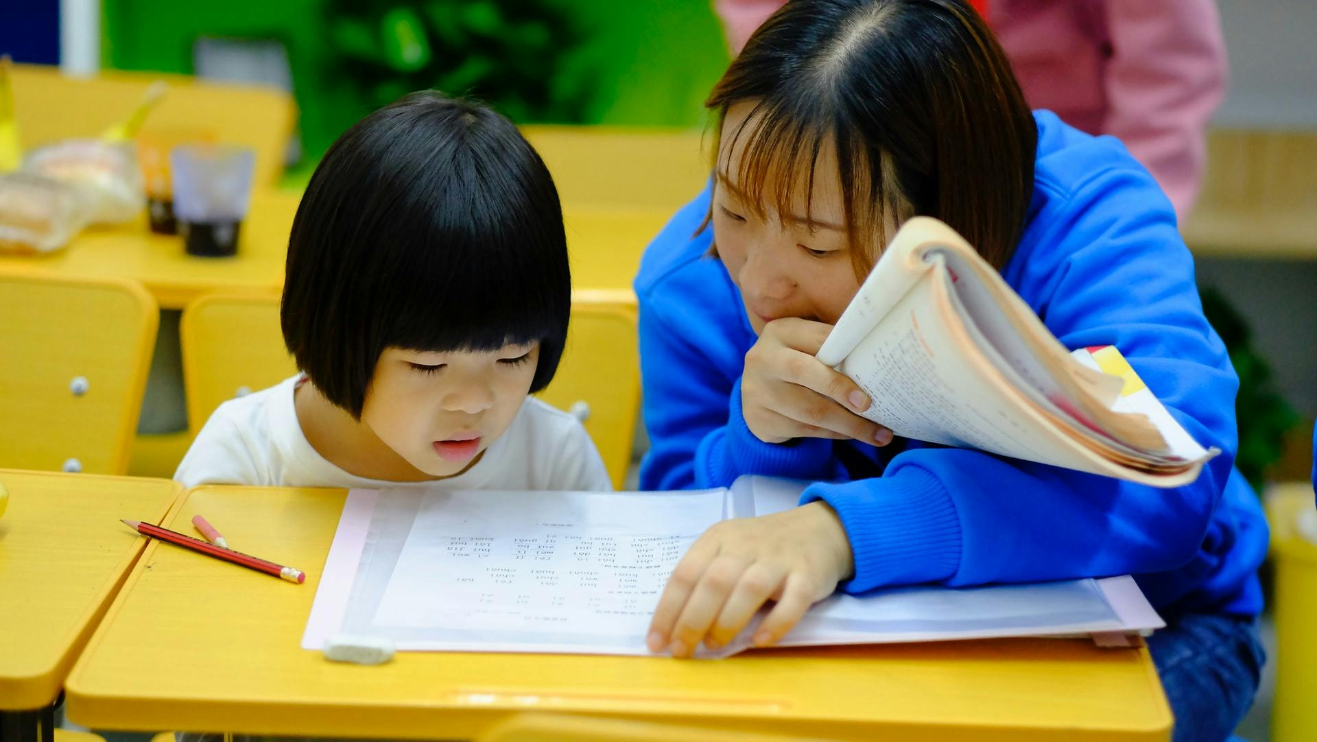 A teacher and a student work together in the classroom on phonemic and phonological awareness activities.