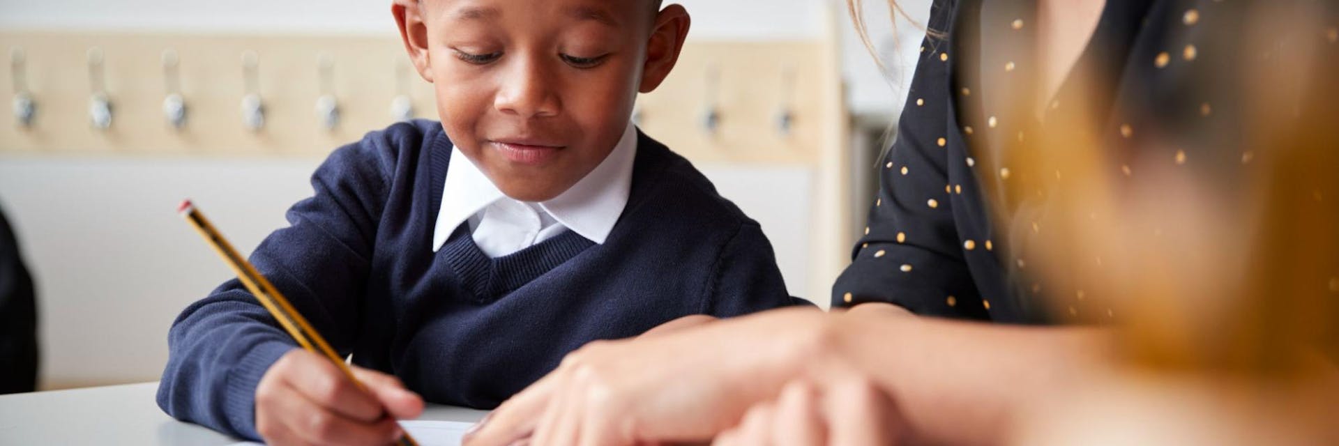 A teacher and student work together in the classroom on vocabulary strategies.