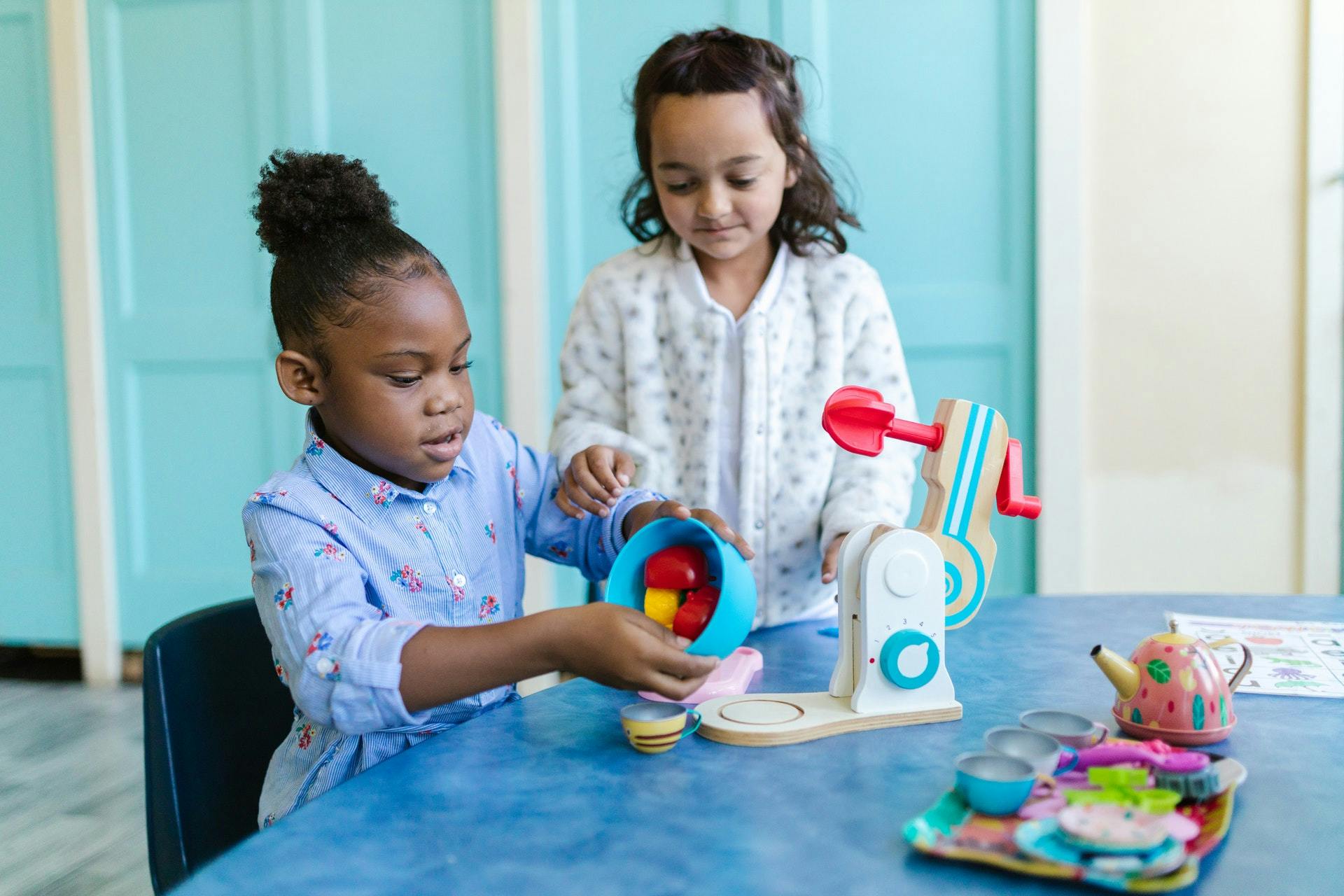 Two girls play with toys during play-based learning activities.