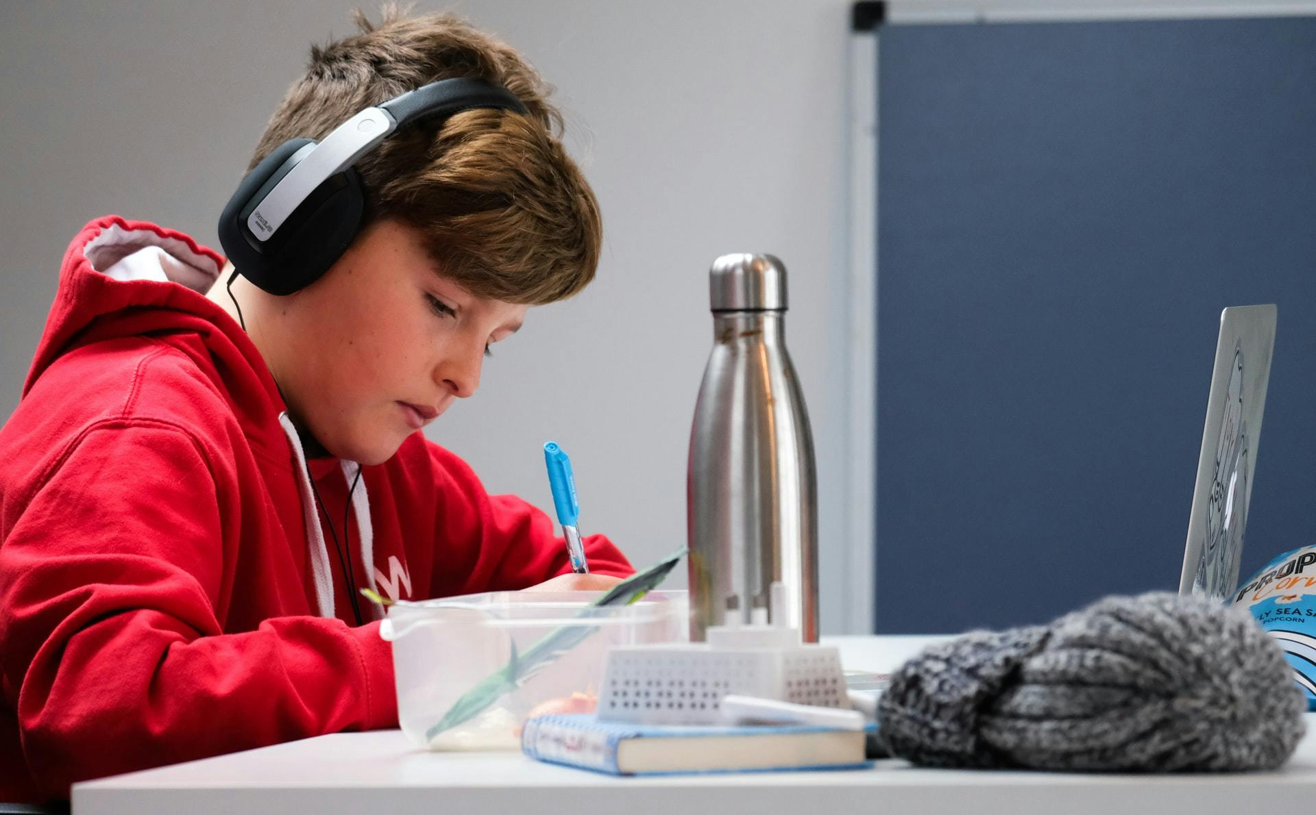A young boy wears headphones and uses aural study strategies to prepare for his test.