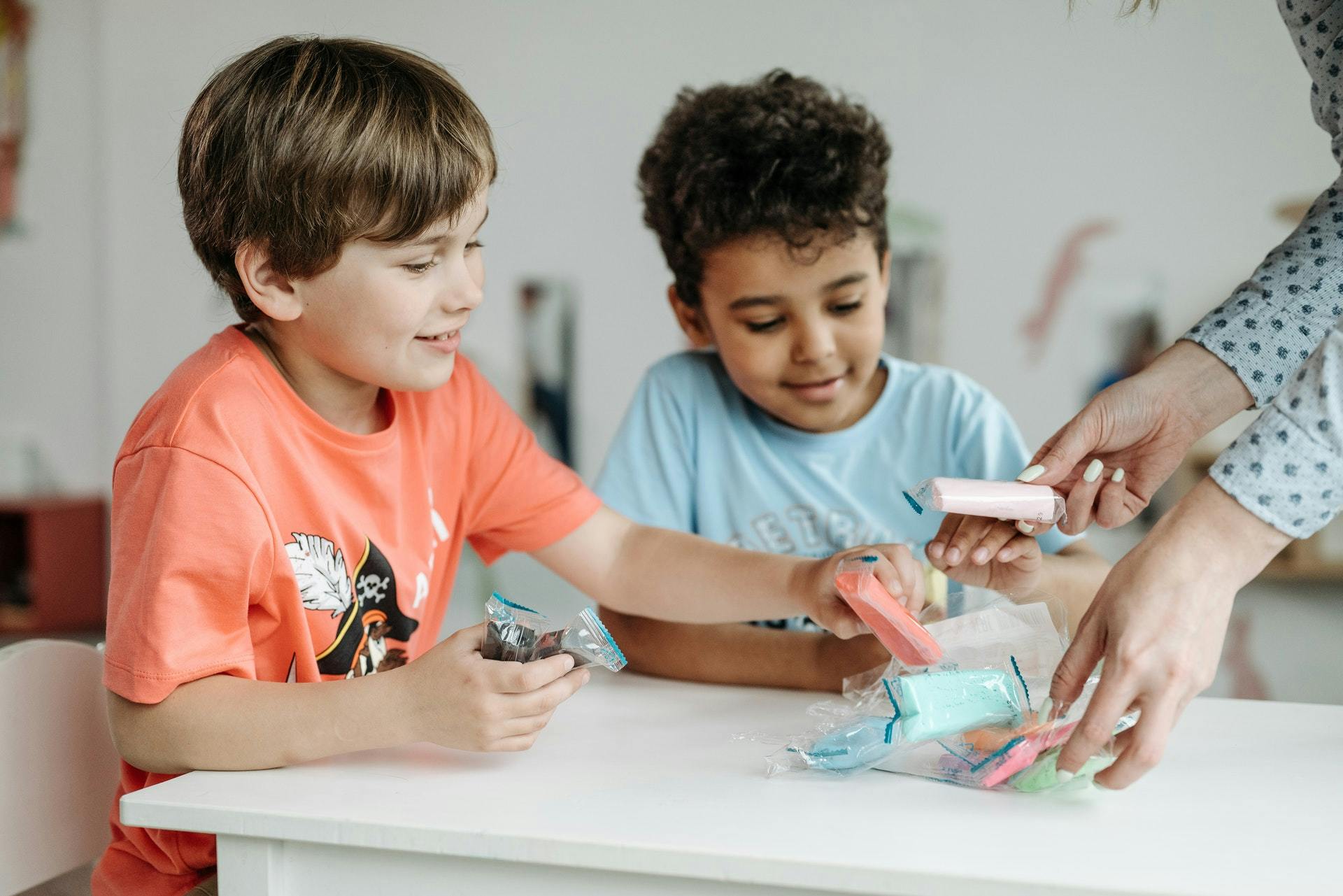 Two boys play with clay in the classroom.