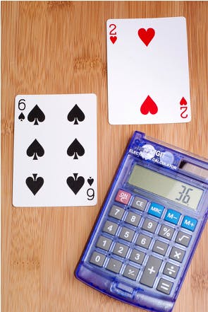 Two playing cards with a calculator.
