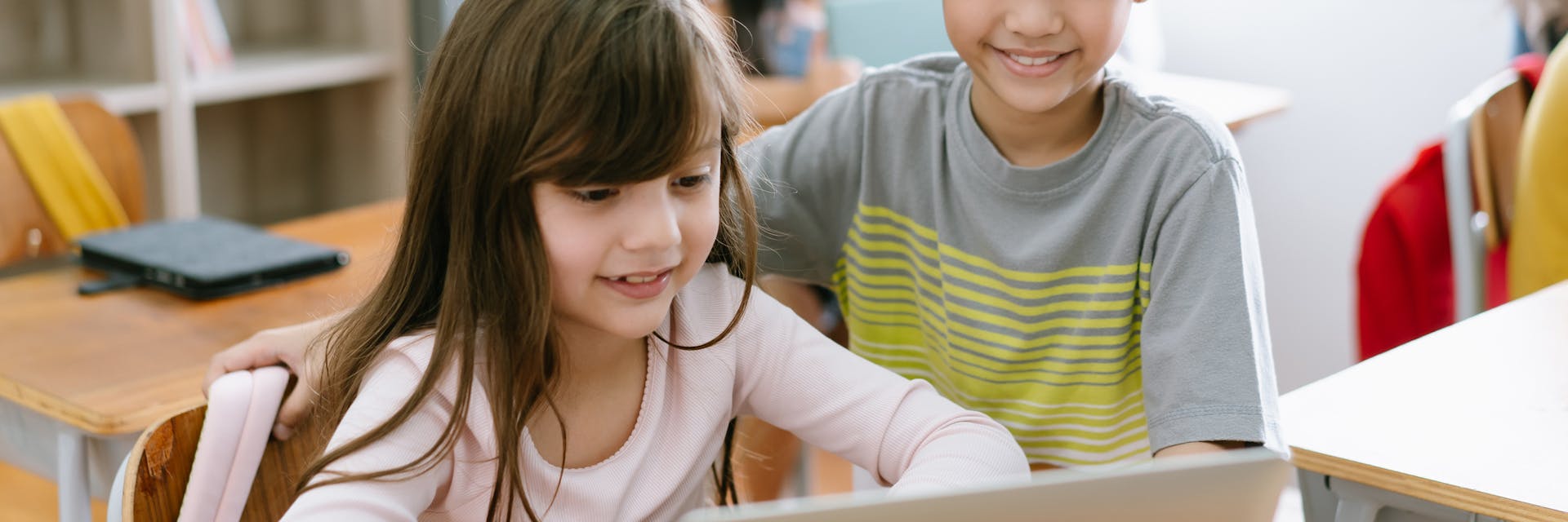 Two students play Prodigy on a computer