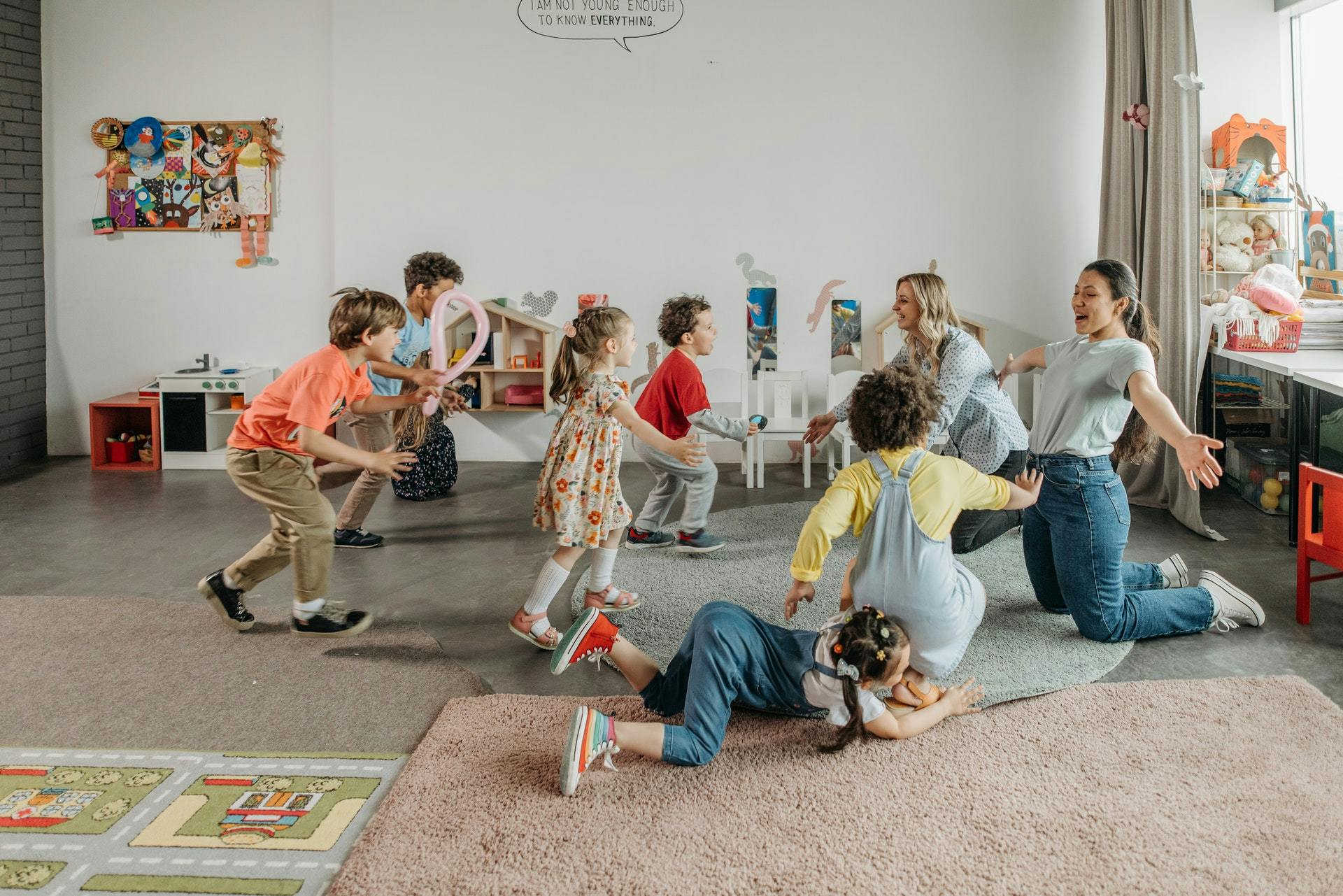 Two teachers and a classroom full of students use play-based learning activities.