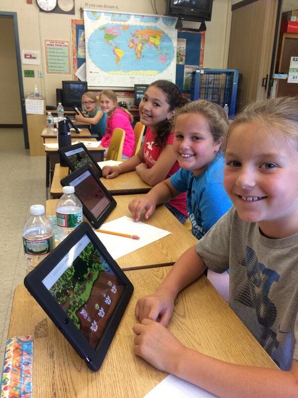 Five students are smiling and playing Prodigy Math game