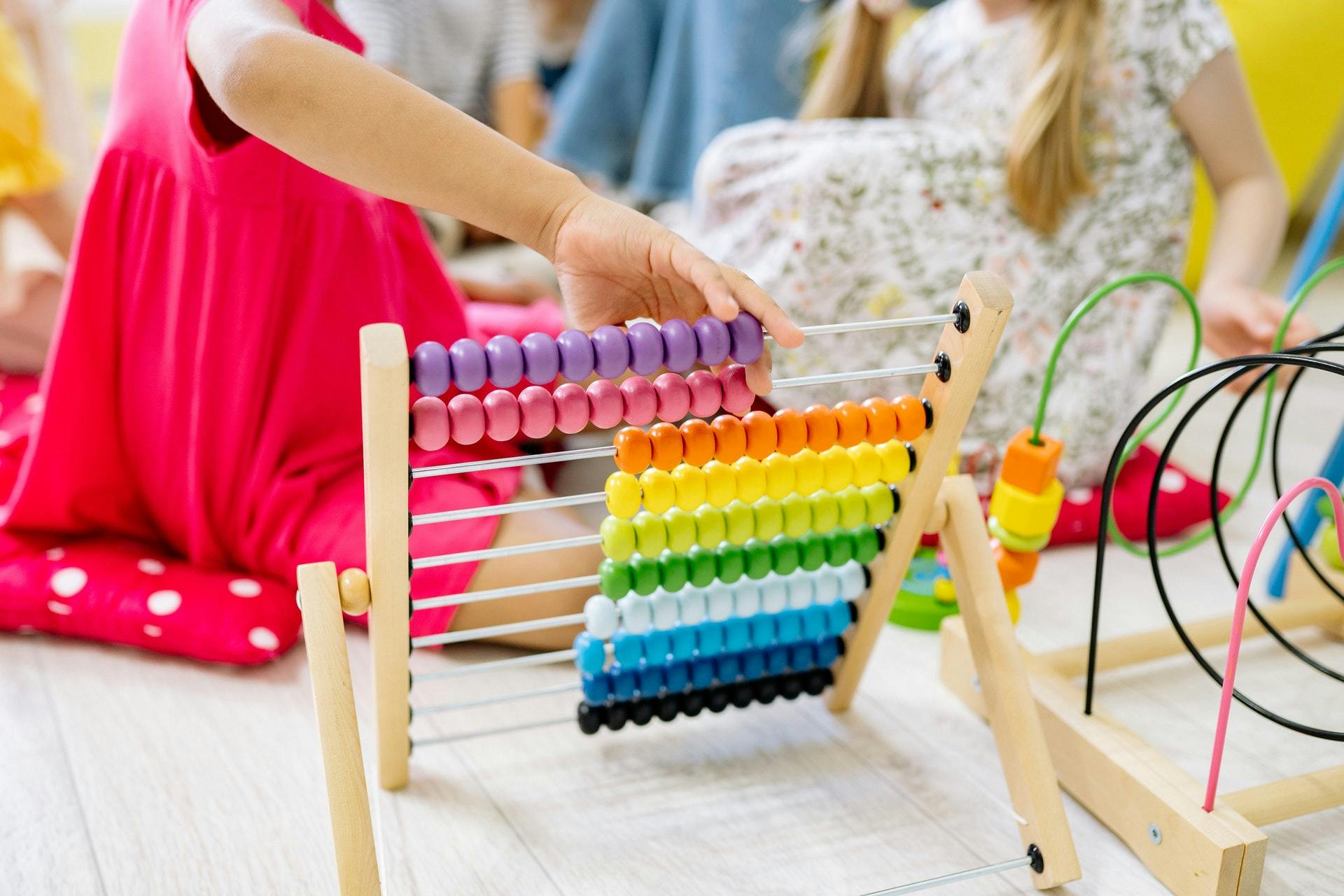 Kindergartener plays with an abacus during math addition games. 