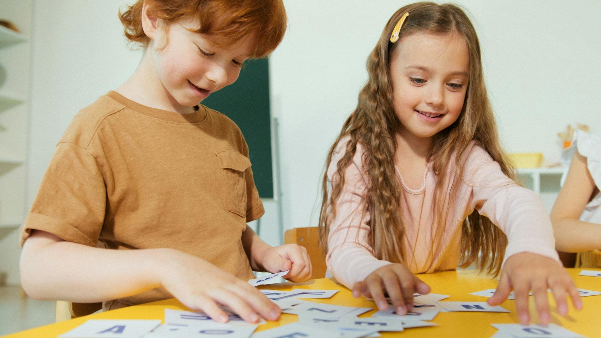 Two students work on a play-based learning activity in their classroom.