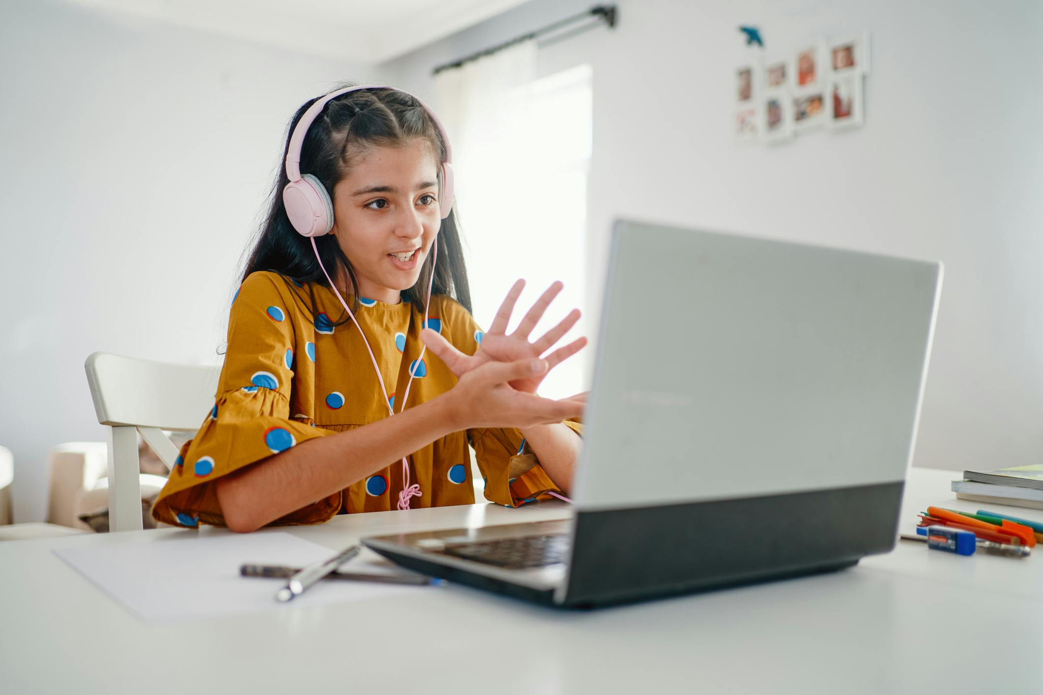 Student on laptop wearing headphones and chatting to others online