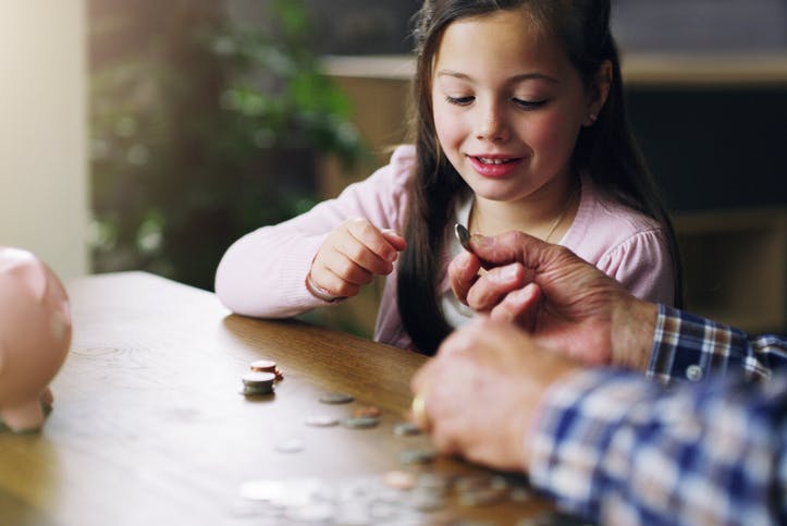 A young girl practicing counting coins to enforce math skills.