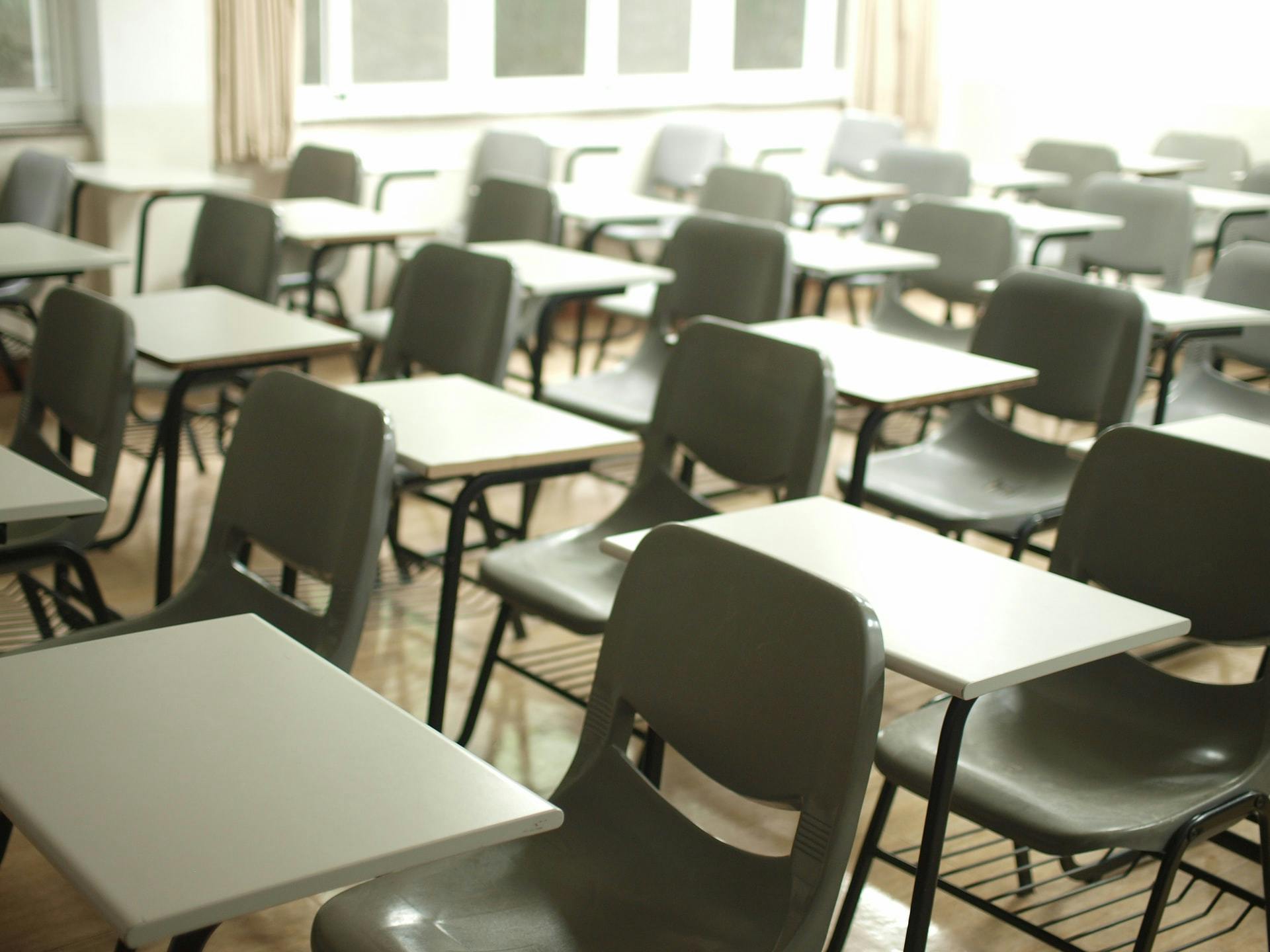 Classroom filled with rows of empty desks.