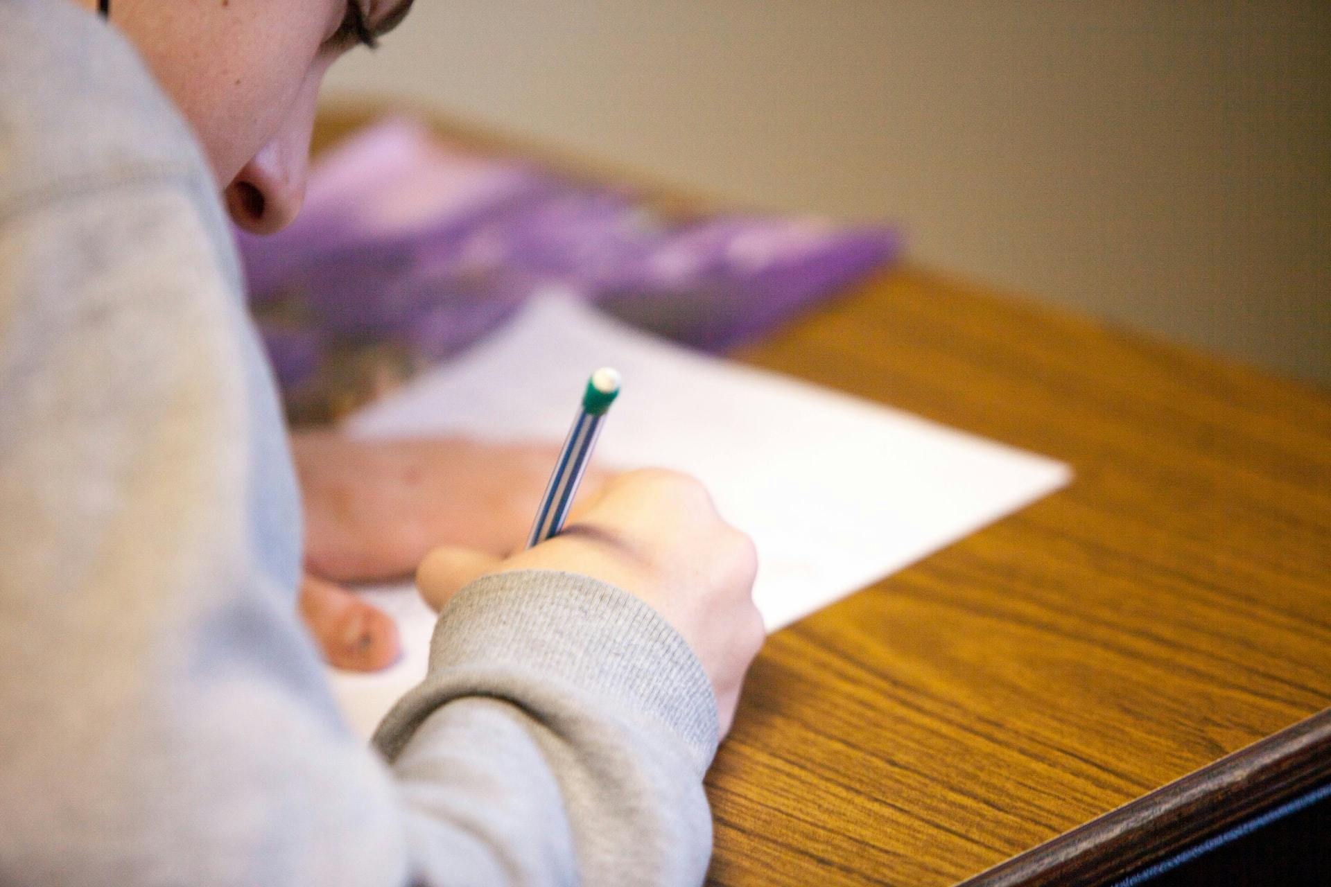 A student completes a learning activity align to Bloom's taxonomy with a pencil and paper at their desk.