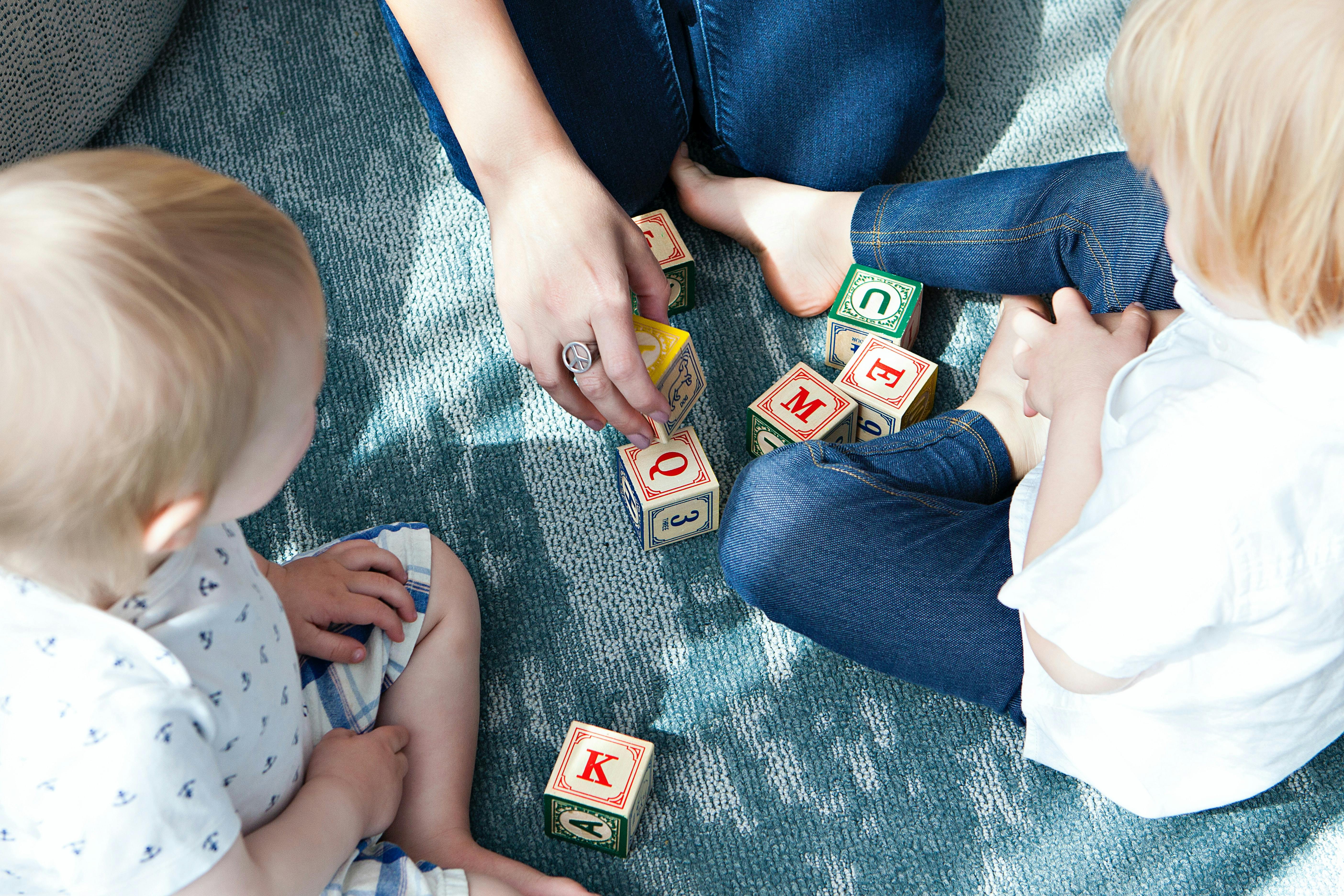 A parent and their children practicing number and letter recognition to prepare for first grade.