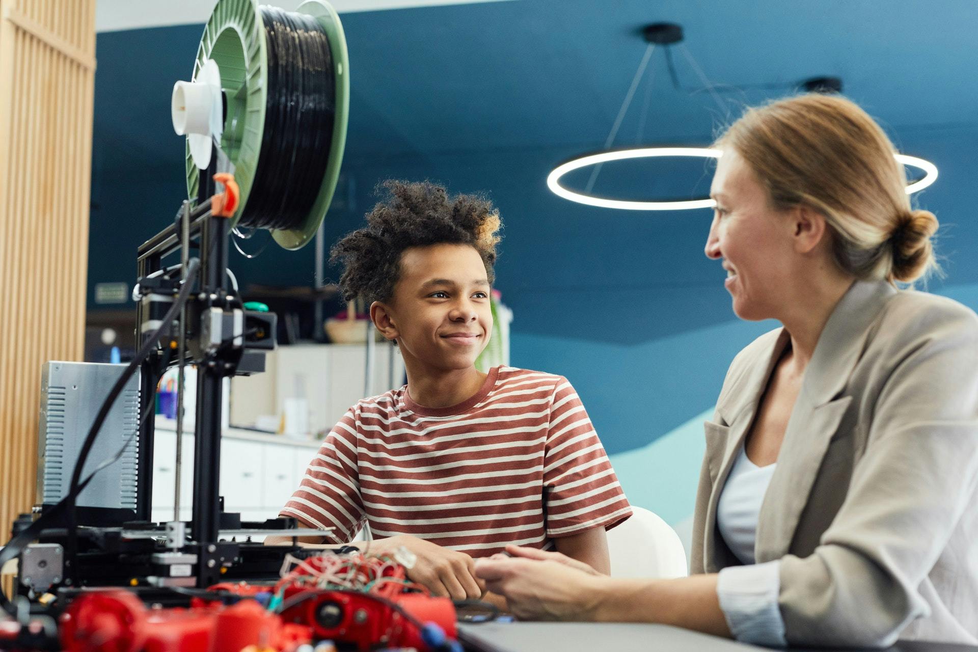 A male student works with a female tutor on a science project.