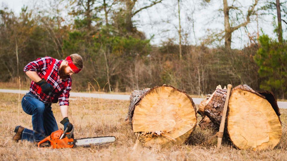 Person startar bensindriven motorsåg