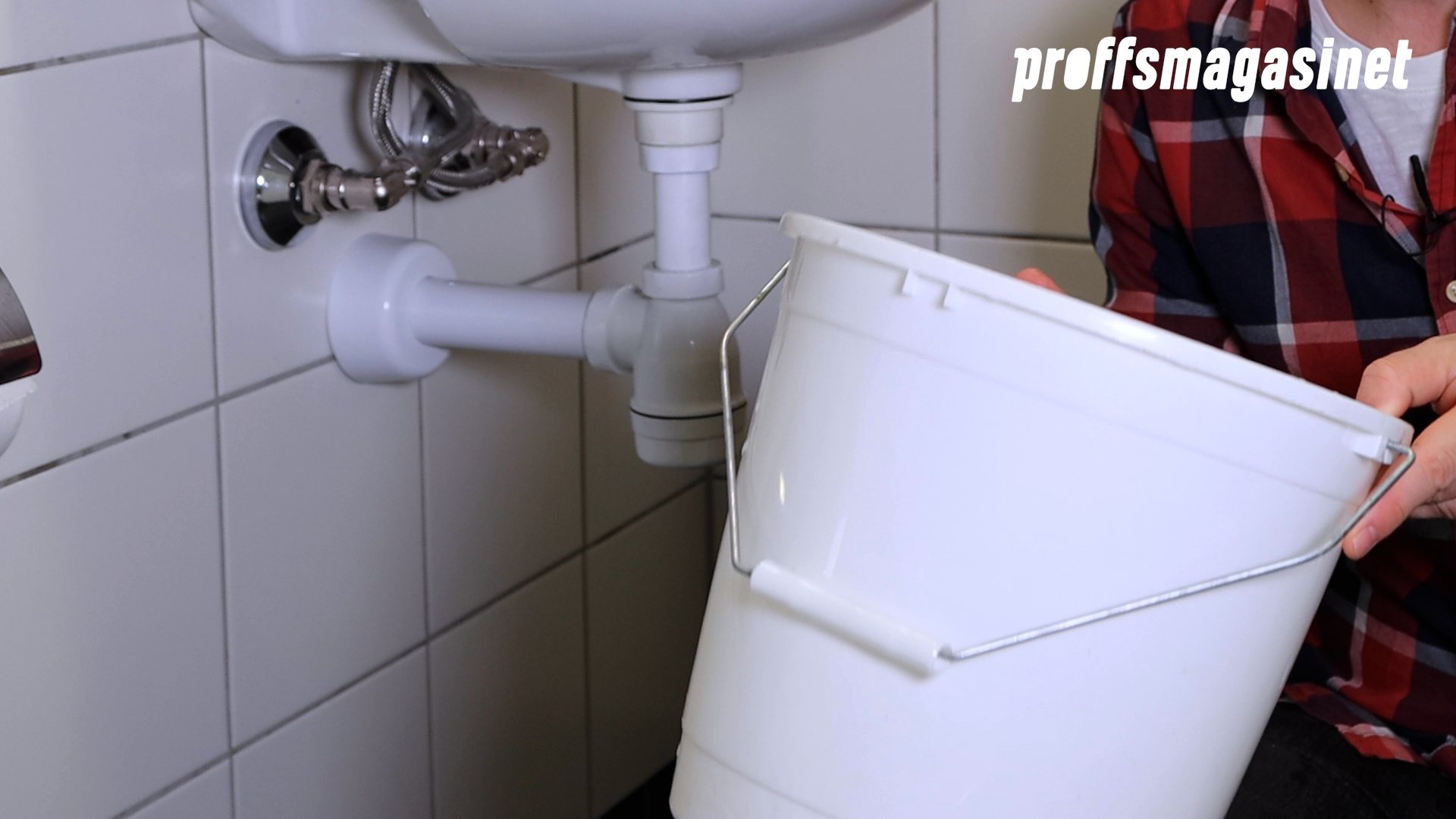 Person håller hink under handfat