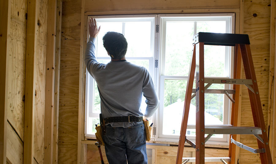 Person monterer vindu innendørs