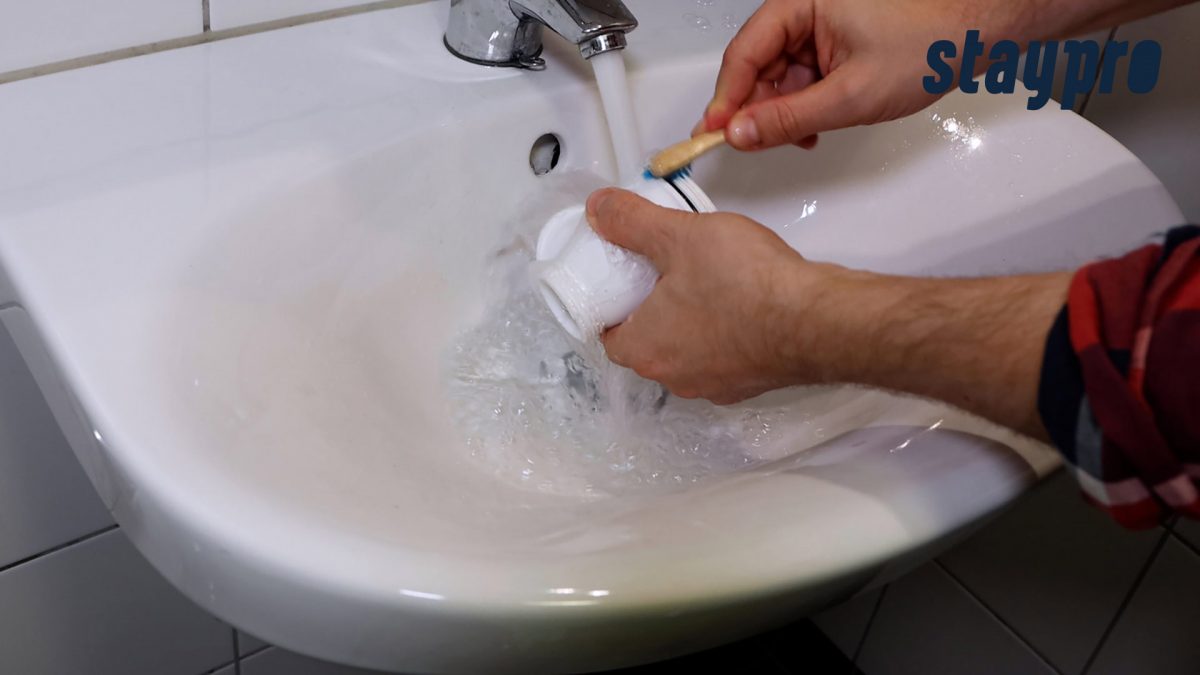 Person rengjør delene med en tannbørste